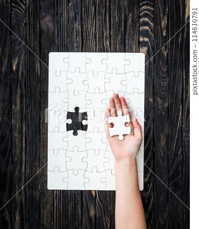 hand with the last piece of white uncomleted puzzle hand with the last piece of white uncomleted puzzle 114610791