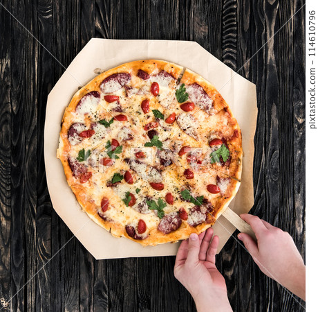 hands taking a portion of delicious pizza 114610796