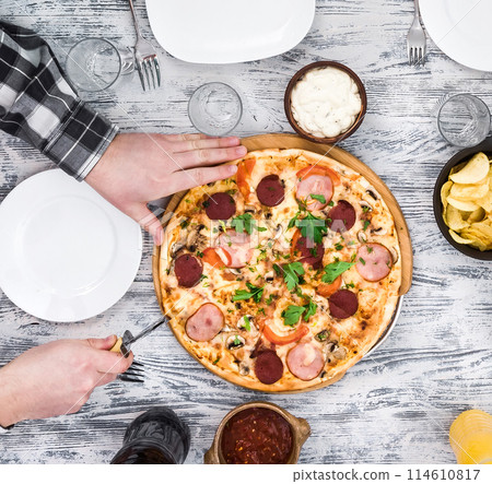 hands cutting pizza on table hands cutting pizza on table 114610817