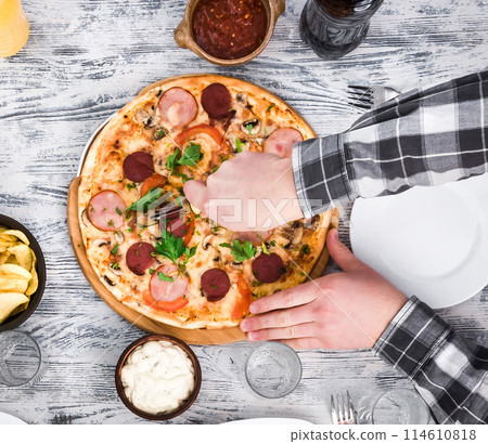 hands cutting pizza on table hands cutting pizza on table 114610818