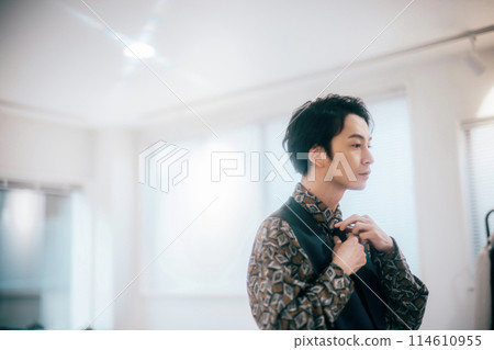 A young groom getting ready in his room A young groom getting ready in his room 114610955