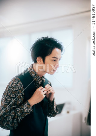 A young groom getting ready in his room A young groom getting ready in his room 114610957
