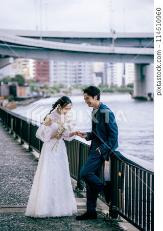 Bride and groom having a pleasant conversation by the river 114610960