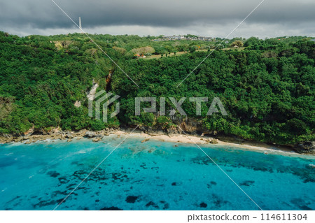 Drone view of cliff coastline with turquoise ocean and beach in Bali 114611304