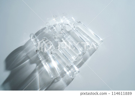 Several ampoules for injection with medicines on a blue background. 114611889