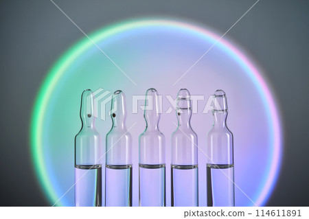 Several ampoules for injection with medicines on a blue background. Several ampoules for injection with medicines on a blue background. 114611891