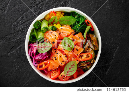 Salmon poke bowl with vegetables and greens in cardboard cup 114612763