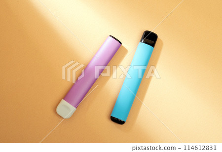 disposable electronic cigarettes with shadow on a beige background with copy space. The concept of modern smoking, vaping and nicotine. 114612831