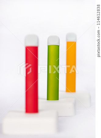 Set of colorful disposable electronic cigarettes on a display stand on a white background. The concept of modern smoking, vaping and nicotine. 114612838