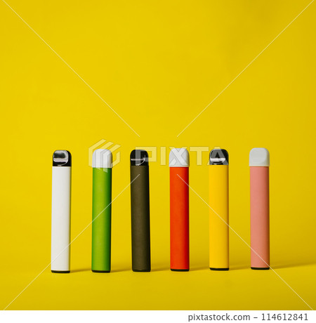 Set of colorful disposable electronic cigarettes with shadows on a yellow background. The concept of modern smoking, vaping and nicotine 114612841