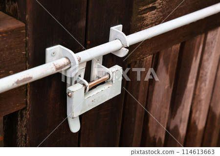 Old Japan style lock on the door. lock on the wooden door close-up. Traditional Japanese lock hanging on the wooden door. 114613663