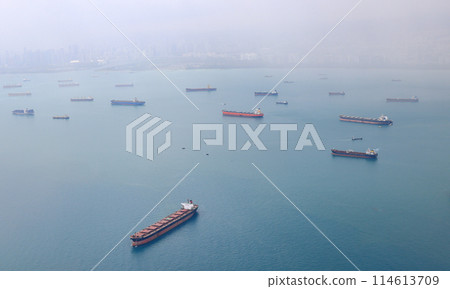 Aerial view of the Singapore Strait, Ocean liner, tanker and Cargo Ship with rainstorm in Singapore Strait, View from plane. 114613709