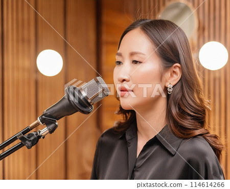 Female vocalist recording in a recording studio 1 114614266