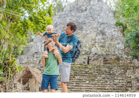 Dad with two sons tourists at Coba, Mexico. Ancient mayan city in Mexico. Coba is an archaeological area and a famous landmark of Yucatan Peninsula. Cloudy sky over a pyramid in Mexico 114614959