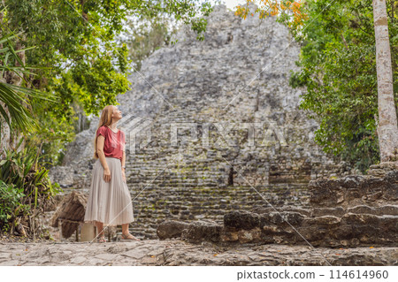 Woman tourist at Coba, Mexico. Ancient mayan city in Mexico. Coba is an archaeological area and a famous landmark of Yucatan Peninsula. Cloudy sky over a pyramid in Mexico 114614960