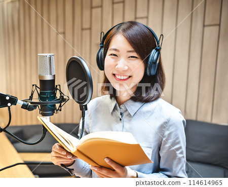 Female voice actor holding a script and dubbing an animation 2 114614965
