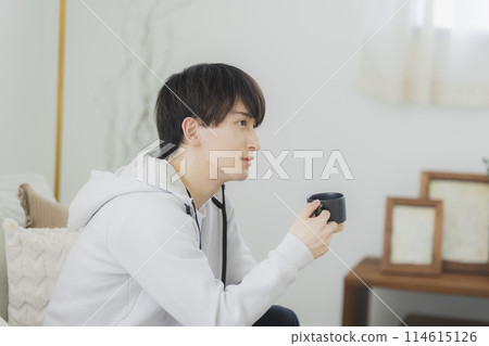 Young man relaxing in the living room 114615126