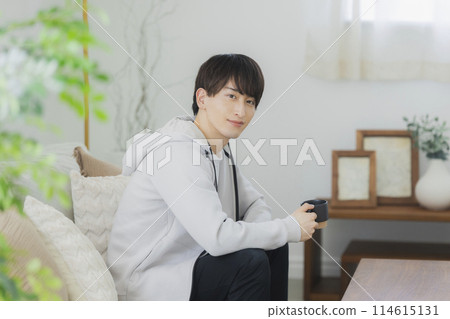 Young man relaxing in the living room 114615131
