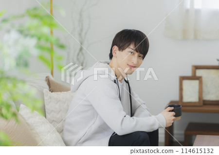 Young man relaxing in the living room Young man relaxing in the living room 114615132