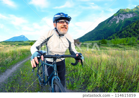 bearded man cyclist rides a bike on a road in nature. sports, hobbies and entertainment for health 114615859