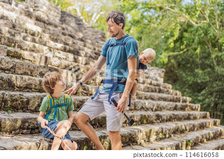 Dad with two sons tourists at Coba, Mexico. Ancient mayan city in Mexico. Coba is an archaeological area and a famous landmark of Yucatan Peninsula. Cloudy sky over a pyramid in Mexico Dad with two sons tourists at Coba, Mexico. Ancient mayan city in Mexico. Coba is an archaeological area and a famous landmark of Yucatan Peninsula. Cloudy sky over a pyramid in Mexico 114616058