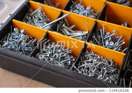 A wood flooring with a toolbox containing screws and drills A wood flooring with a toolbox containing screws and drills 114616106