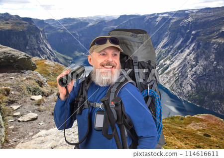 bearded man traveler with tourist equipment and binoculars in hand 114616611