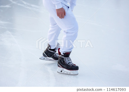legs of a skater on an ice rink. hobbies and winter sports 114617093