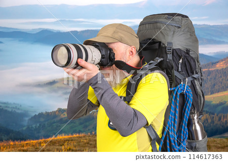 tourist photographer with a backpack photographs the beauty of nature in the mountains 114617363