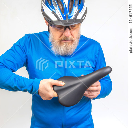 male cyclist checks the softness of his bicycle saddle. sports and transport equipment male cyclist checks the softness of his bicycle saddle. sports and transport equipment 114617365