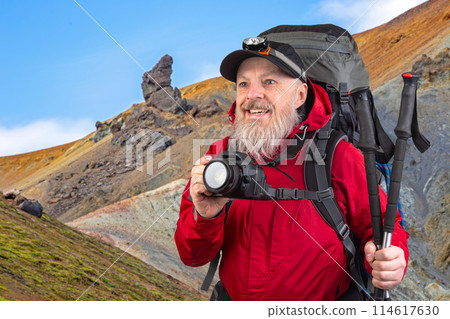 bearded man tourist photographer with a backpack photographs the beauty of nature  bearded man tourist photographer with a backpack photographs the beauty of nature  114617630