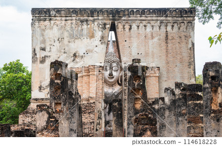Huge Buddha statue inside a roofed building of Wat Si Chum temple located in the North zone of the Sukhothai Historical Park outside the walled city. Huge Buddha statue inside a roofed building of Wat Si Chum temple located in the North zone of the Sukhothai Historical Park outside the walled city. 114618228