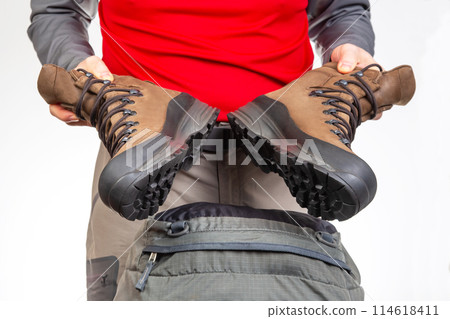 Tourist advertises and shows trekking boots. Clothing for tourism and travel 114618411