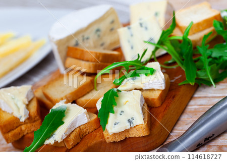 Blue cheese served with toast and arugula Blue cheese served with toast and arugula 114618727