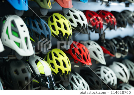 Variety of bicycle helmets displayed in cycling equipment shop Variety of bicycle helmets displayed in cycling equipment shop 114618760