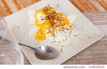 Homemade hearty breakfast - cottage cheese with honey sauce. dish is richly decorated with sesame Homemade hearty breakfast - cottage cheese with honey sauce. dish is richly decorated with sesame 114618829