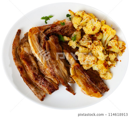Fried lamb served with cauliflower on platter 114618913