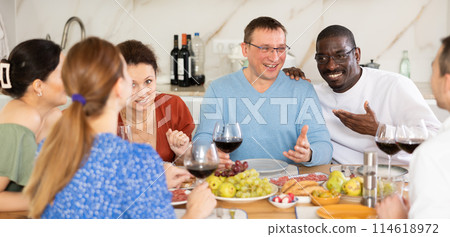 Multiethnic women and men friends chatting and drinking 114618972