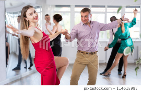 Woman and man dancing foxtrot in pair during group dance party Woman and man dancing foxtrot in pair during group dance party 114618985