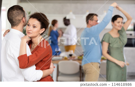 Friends party - men and women of different nationalities dancing slow dance at home Friends party - men and women of different nationalities dancing slow dance at home 114618986