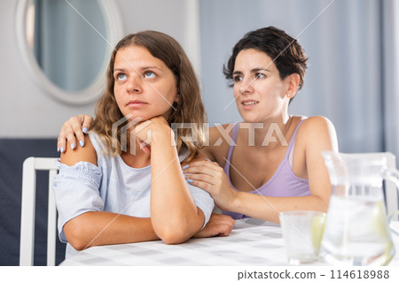 Beautiful girl with dark hair keep arms folded, do not talk to her friend 114618988