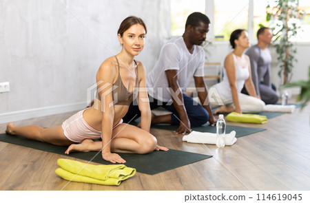 Sporty people of different nationalities practicing yoga lesson at sport club 114619045