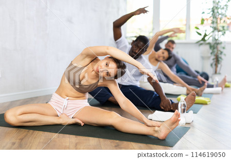 Group of people of different nationalities do stretching during yoga or pilates class Group of people of different nationalities do stretching during yoga or pilates class 114619050
