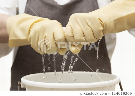 擰乾抹布,戴上橡膠手套擰乾 擰乾抹布,戴上橡膠手套擰乾 114619269