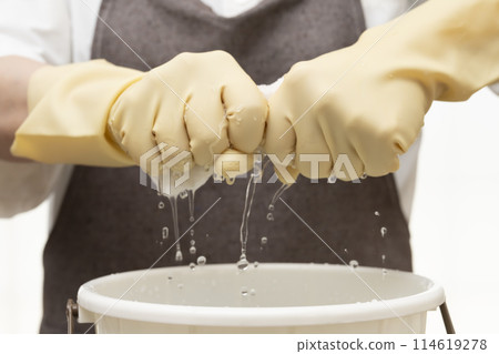 擰乾抹布,戴上橡膠手套擰乾 擰乾抹布,戴上橡膠手套擰乾 114619278