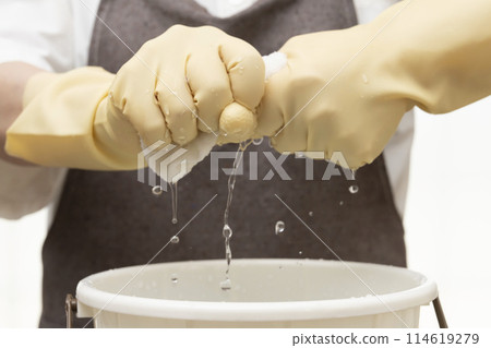 Wring out the rag Wring out the rag with rubber gloves 114619279