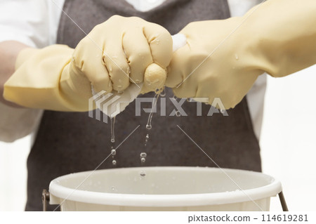 擰乾抹布,戴上橡膠手套擰乾 擰乾抹布,戴上橡膠手套擰乾 114619281