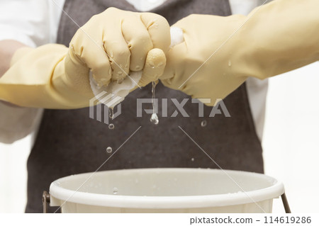擰乾抹布,戴上橡膠手套擰乾 擰乾抹布,戴上橡膠手套擰乾 114619286