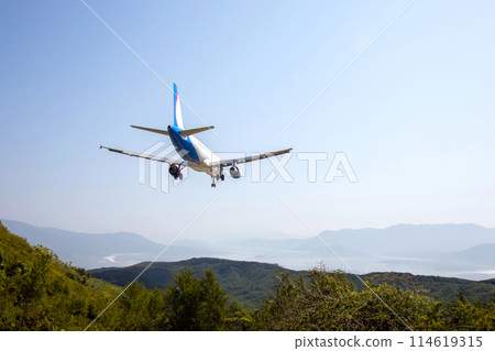 passenger plane flies over a mountain valley. air transport industry passenger plane flies over a mountain valley. air transport industry 114619315