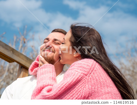 Romantic portrait of young married russian couple, woman kissing her husband Romantic portrait of young married russian couple, woman kissing her husband 114619516